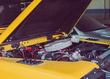Engine bay of a yellow classic automobile